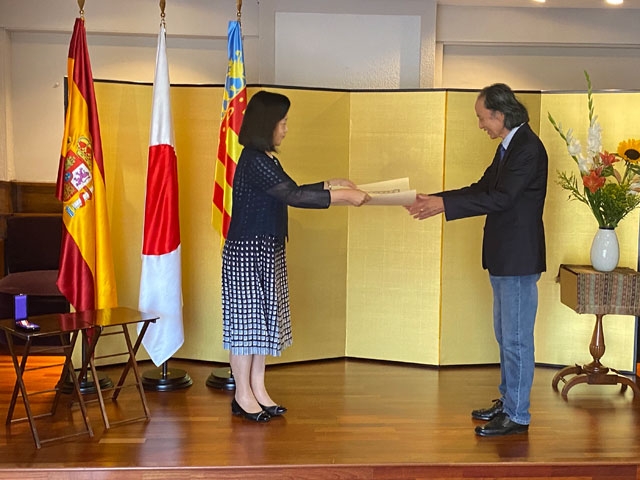 La Cónsul General Shikata entrega el diploma por la condecoración a Kazuyuki Shiraishi ante un biombo dorado