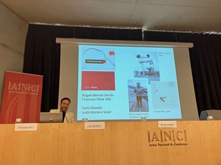 El doctor Ricard Bru sentado ante la proyección del power point de la conferencia Catalunya-Japó: història d’una amistat