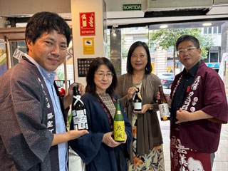 La Cónsul General junto a tres personas que enseñan tres botellas de sake de Okayama