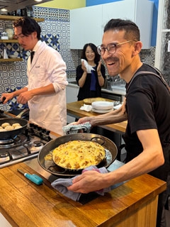 El chef Atsushi TAKATA y el chef Koichi KUWABARA cocinando y mostrando una paella con su creación