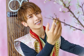 Yoshiaki Okawa junto a una rama de cerezo y con el arpa koto de fondo