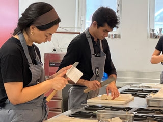 Dos de los cocineros participantes en el curso cortando ingredientes