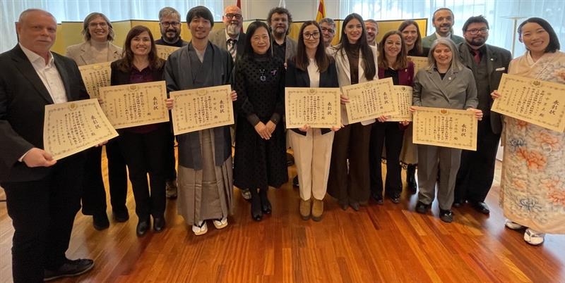 La Cónsul General junto a los 17 premiados que muestran sus diplomas