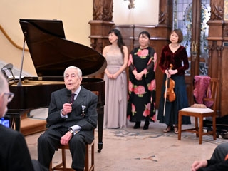 El Sr. Voltà presenta el evento ante un piano y las tres intérpretes