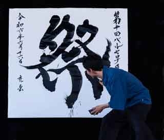 Mitsuru Nagata creando una obra de caligrafía shodo de gran formato con el kanji de Matsuri