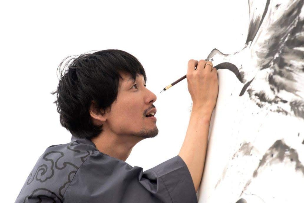 El artista Mitsuru NAGATA creando una obra Sumi-e de una grulla